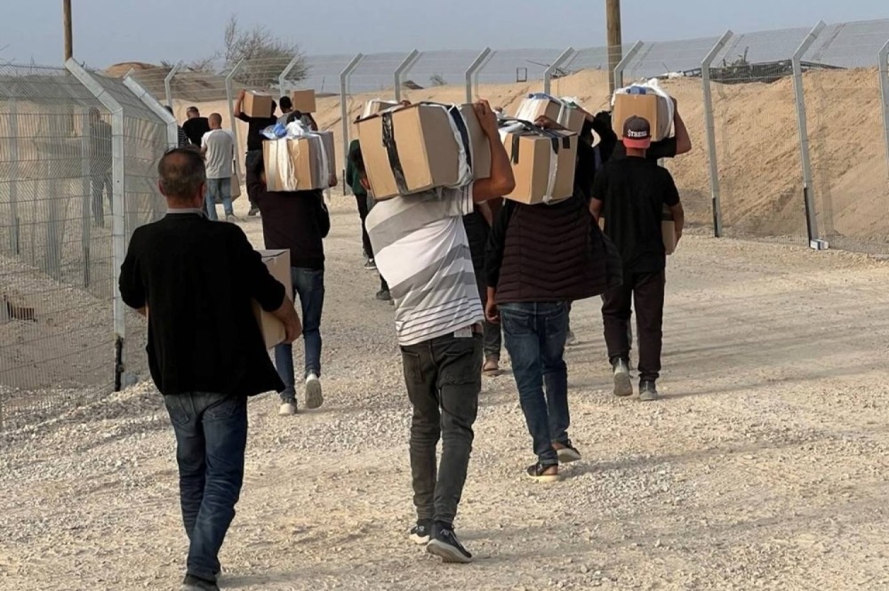 غزيون يحملون المساعدات